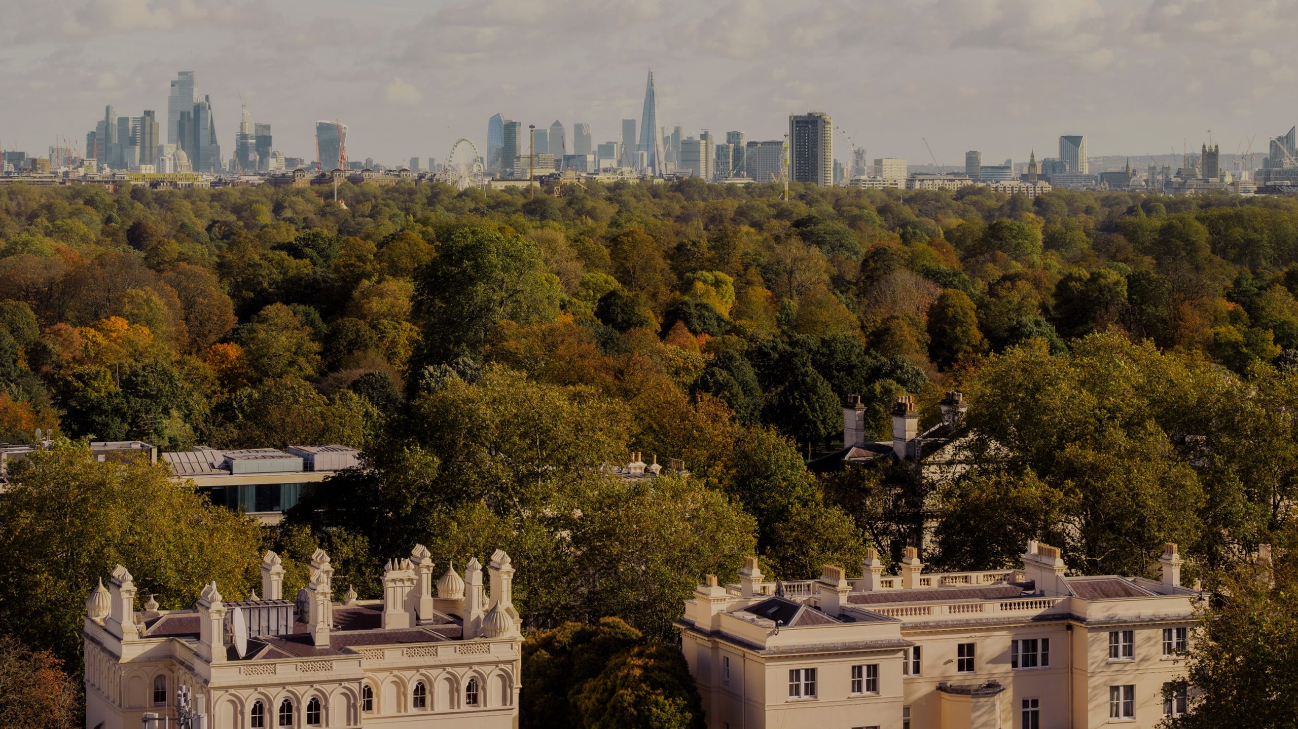 London skyline with The Shard and city skyscrapers viewed across autumnal park treetops and white stucco townhouses